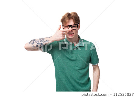 portrait of a young man with red hair dressed in a green T-shirt grimacing 112525827