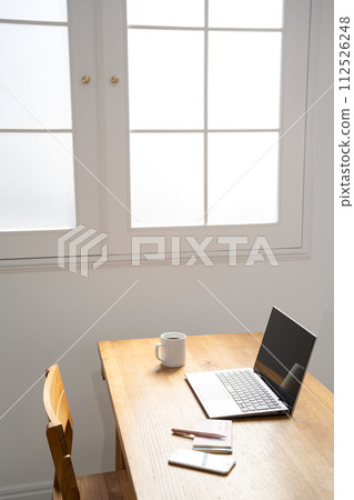 Laptop computer on the table at the window Laptop computer on the table at the window 112526248