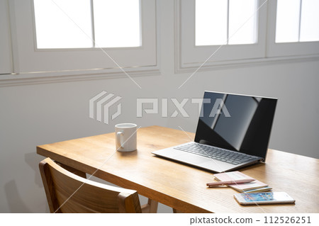 Laptop computer on the table at the window Laptop computer on the table at the window 112526251