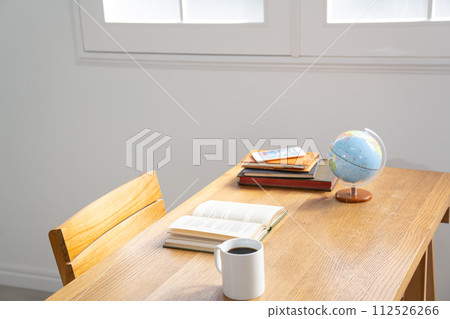 Old foreign books and a globe placed on a table by the window Old foreign books and a globe placed on a table by the window 112526266