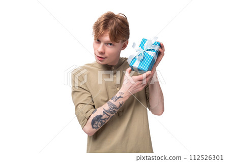 a young red-haired guy in glasses and a brown shirt decides who to give a gift box with a surprise 112526301