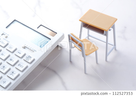 School desks, chairs, and calculators give an image of education costs that continue to rise and put pressure on household budgets. School desks, chairs, and calculators give an image of education costs that continue to rise and put pressure on household budgets. 112527353