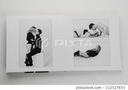 The pages of a photo book with a photo of a pregnant blonde and a man.  112527655