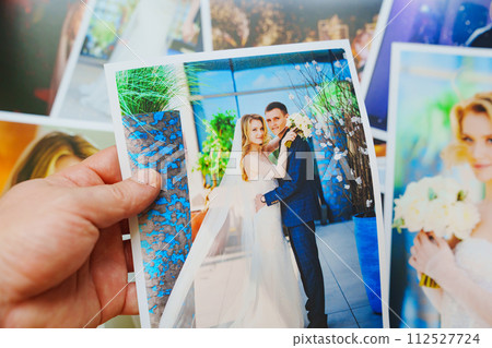 men's hands lay out Beautiful printed wedding photos. Professional photography. 112527724