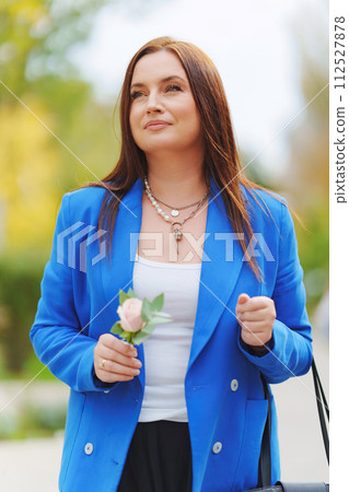 Attractive brunette woman in blue jacket with Rose Flower.  112527878