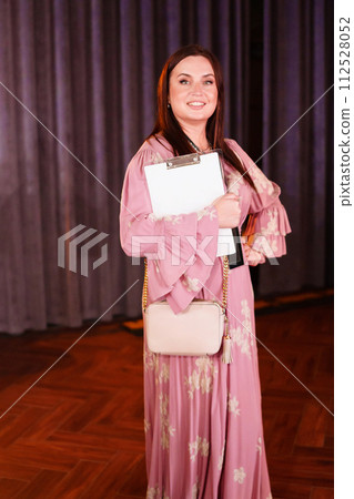 woman in a pink dress with a badge at the party 112528052