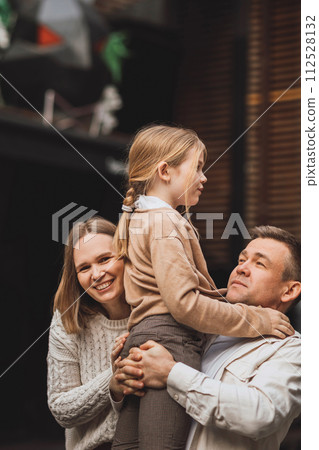Happy family on a walk in the city. Mom, dad and teenage daughter having fun. 112528132