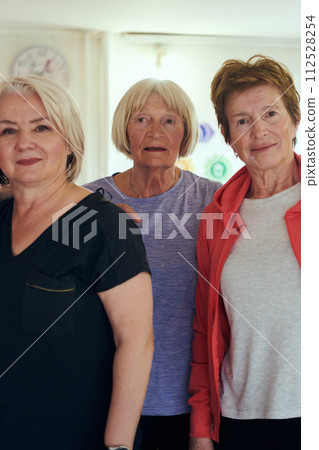 A vibrant community of senior women, guided by their instructor, embraces the enriching journey of yoga, fostering unity, well-being, and a shared commitment to active aging A vibrant community of senior women, guided by their instructor, embraces the enriching journey of yoga, fostering unity, well-being, and a shared commitment to active aging 112528254