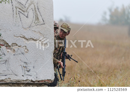 In a high stakes mission, a specialized military unit executes a tactical operation to secure a dangerous house where terrorists are believed to be hiding, showcasing precision and coordinated 112528569