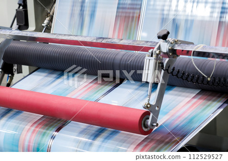 new innovative technology of automatic label printing machine with digital control panel. printing on continuous plastic film for wrapping on food product packaging in the printing factory. new innovative technology of automatic label printing machine with digital control panel. printing on continuous plastic film for wrapping on food product packaging in the printing factory. 112529527