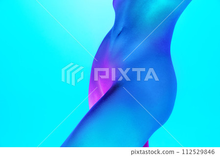 Cropped photo of of female belly, breast with focus on perfect curves and form in neon light against gradient cyan background. 112529846