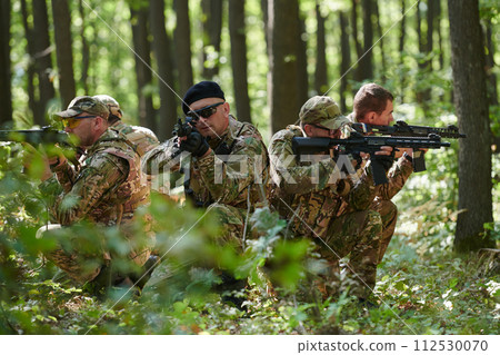 A specialized military antiterrorist unit conducts a covert operation in dense, hazardous woodland, demonstrating precision, discipline, and strategic readiness 112530070