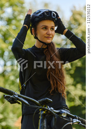 In the radiant embrace of a sunny day, a joyous girl, adorned in professional cycling gear, finds pure bliss and vitality as she cruises through the park on her bicycle, her infectious laughter 112530212