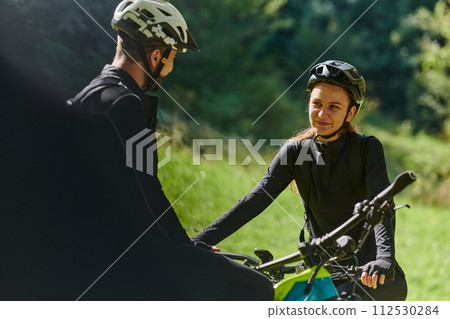 A sweet couple, equipped with bicycles and engrossed in coordinating their journey, checks their GPS mobile and watches while planning scenic routes in the park, seamlessly blending technology and A sweet couple, equipped with bicycles and engrossed in coordinating their journey, checks their GPS mobile and watches while planning scenic routes in the park, seamlessly blending technology and 112530284