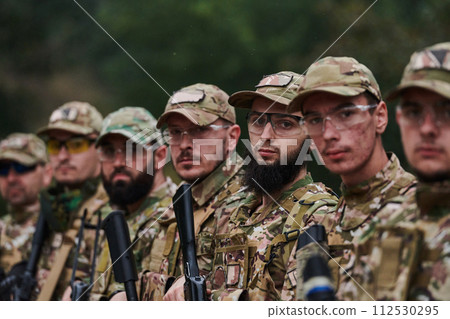 Soldier fighters standing together with guns. Group portrait of US army elite members, private military company servicemen, anti terrorist squad 112530295