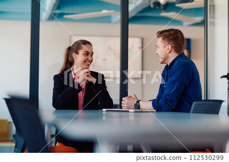 A business leader in a suit conversing with her worker in the IT industry about new business projects and existing business problems 112530299