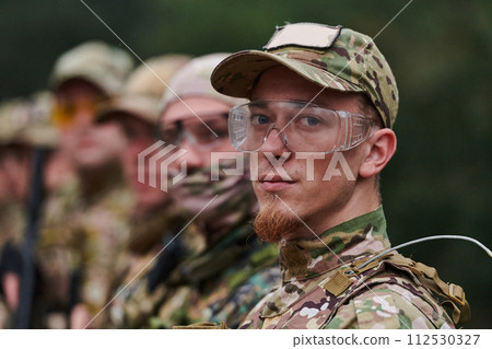 Soldier fighters standing together with guns. Group portrait of US army elite members, private military company servicemen, anti terrorist squad Soldier fighters standing together with guns. Group portrait of US army elite members, private military company servicemen, anti terrorist squad 112530327