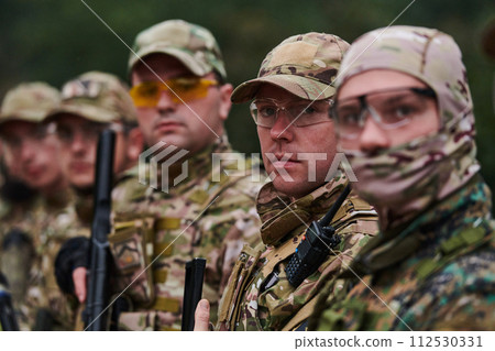 Soldier fighters standing together with guns. Group portrait of US army elite members, private military company servicemen, anti terrorist squad 112530331