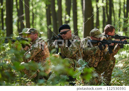 A specialized military antiterrorist unit conducts a covert operation in dense, hazardous woodland, demonstrating precision, discipline, and strategic readiness A specialized military antiterrorist unit conducts a covert operation in dense, hazardous woodland, demonstrating precision, discipline, and strategic readiness 112530391