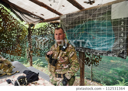 The esteemed leader of an elite military unit, strategic brilliance unfolds as he meticulously devises tactical plans for the upcoming military operation, surrounded by cutting-edge technology and a The esteemed leader of an elite military unit, strategic brilliance unfolds as he meticulously devises tactical plans for the upcoming military operation, surrounded by cutting-edge technology and a 112531364