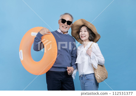 A middle aged man with a tube and a middle aged woman with a wide brim hat A middle aged man with a tube and a middle aged woman with a wide brim hat 112531377