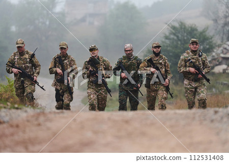 A disciplined and specialized military unit, donned in camouflage, strategically patrolling and maintaining control in a high-stakes environment, showcasing their precision, unity, and readiness for 112531408