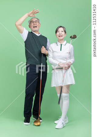 A senior holding a golf club 112531410