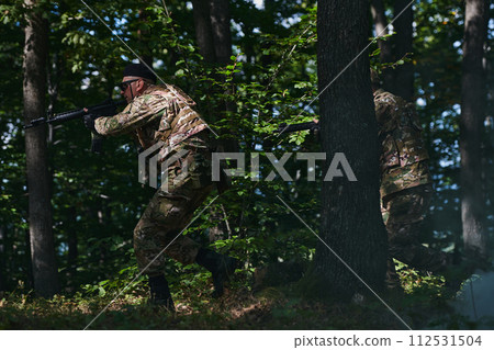 A specialized military antiterrorist unit conducts a covert operation in dense, hazardous woodland, demonstrating precision, discipline, and strategic readiness 112531504