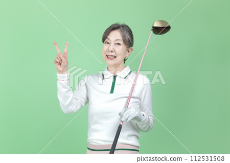 A senior woman holding a golf club 112531508