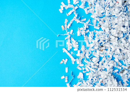 Shredded paper pieces on a blue background Shredded paper pieces on a blue background 112531534