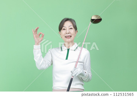 A senior woman holding a golf club 112531565
