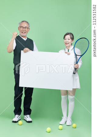 A senior holding a tennis racket, a tennis ball and blank paper 112531582