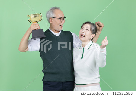 A senior holding a trophy 112531596