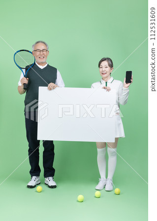A senior holding a tennis racket, a tennis ball and blank paper 112531609