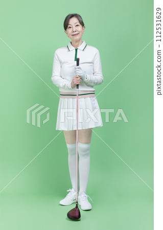 A senior woman holding a golf club 112531629