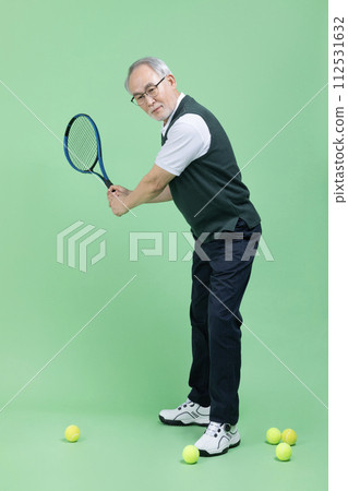 A senior man who plays tennis with a tennis racket 112531632