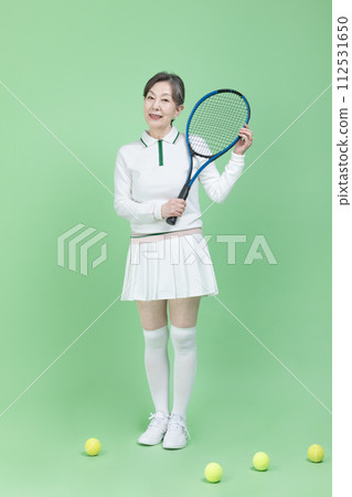 A senior woman holding a tennis racket 112531650