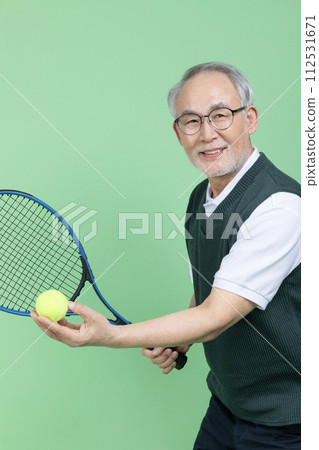 A senior male holding a tennis racket and a tennis ball 112531671