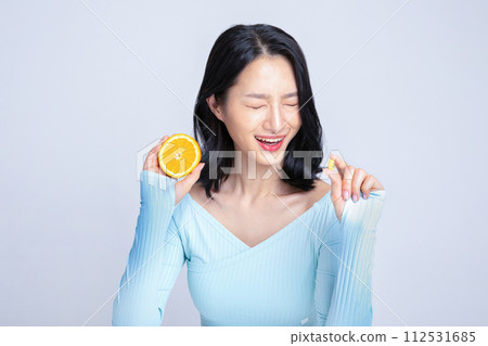 A woman holding a pill and an orange A woman holding a pill and an orange 112531685