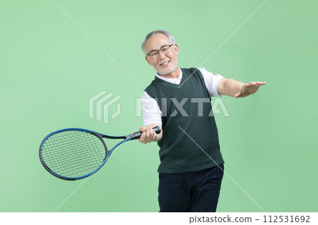 A senior man who plays tennis with a tennis racket 112531692