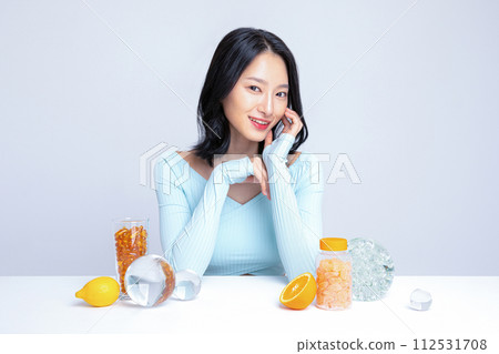 A woman sitting in front of pill lemon tangerine orange A woman sitting in front of pill lemon tangerine orange 112531708