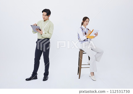 A man and a woman holding a tablet and papers A man and a woman holding a tablet and papers 112531730