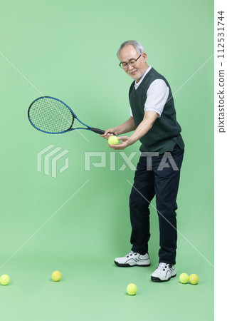 A senior male holding a tennis racket and a tennis ball A senior male holding a tennis racket and a tennis ball 112531744