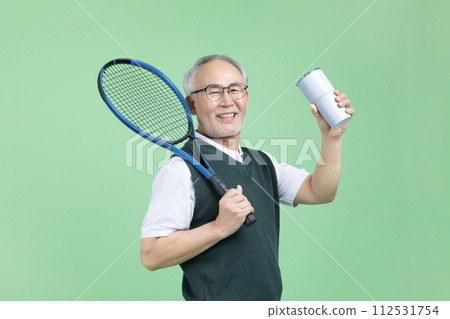 A senior male holding a tennis racket and a water bottle A senior male holding a tennis racket and a water bottle 112531754