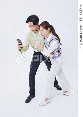 A careful of a man and woman looking at a smartphone 112531770