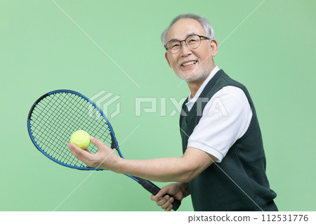 A senior male holding a tennis racket and a tennis ball A senior male holding a tennis racket and a tennis ball 112531776