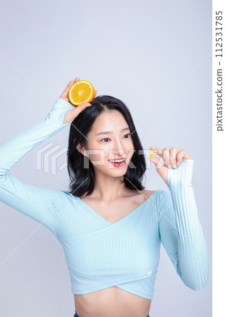 A woman holding a pill and an orange A woman holding a pill and an orange 112531785