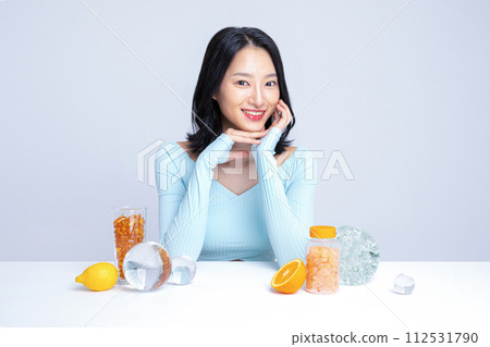 A woman sitting in front of pill lemon tangerine orange A woman sitting in front of pill lemon tangerine orange 112531790