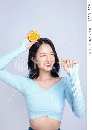 A woman holding a pill and an orange A woman holding a pill and an orange 112531799