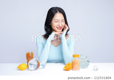 A woman sitting in front of pill lemon tangerine orange A woman sitting in front of pill lemon tangerine orange 112531804